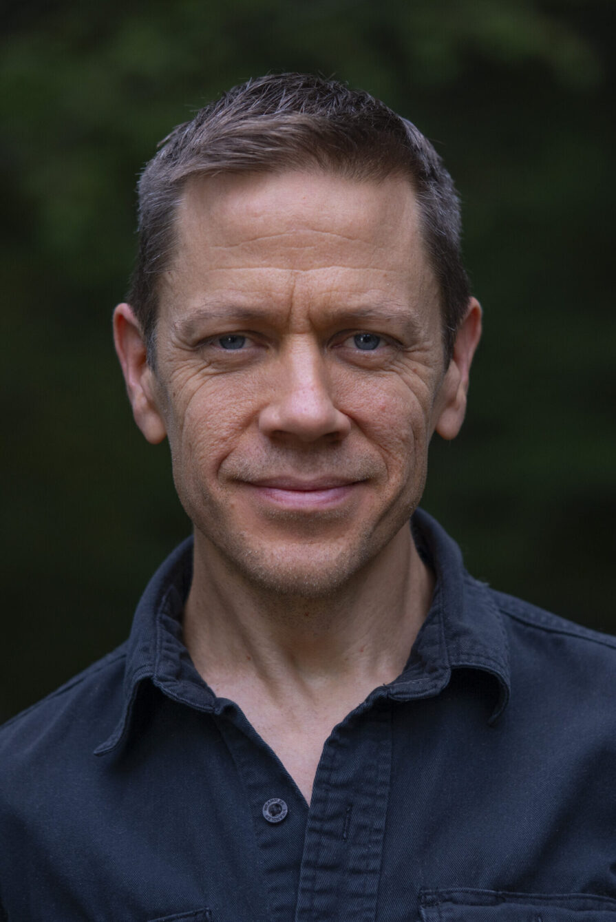 Headshot of David Cooley in blue shirt.