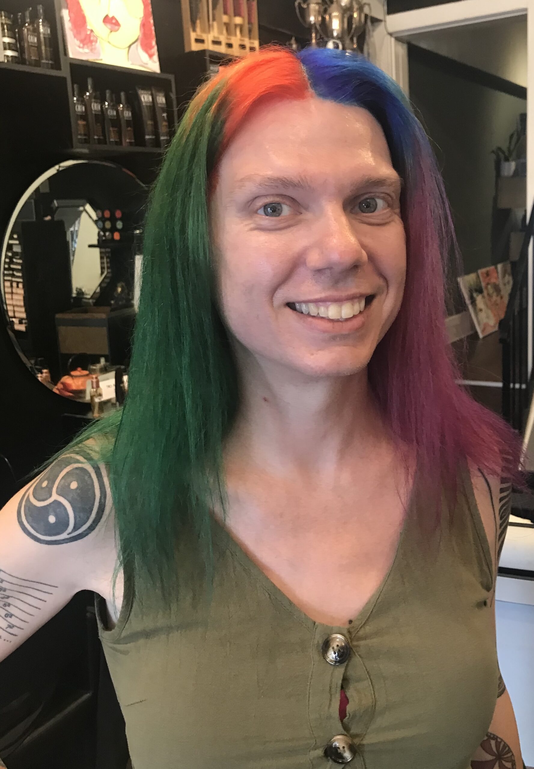 Headshot of Stacey Smith? with rainbow hair in green top.
